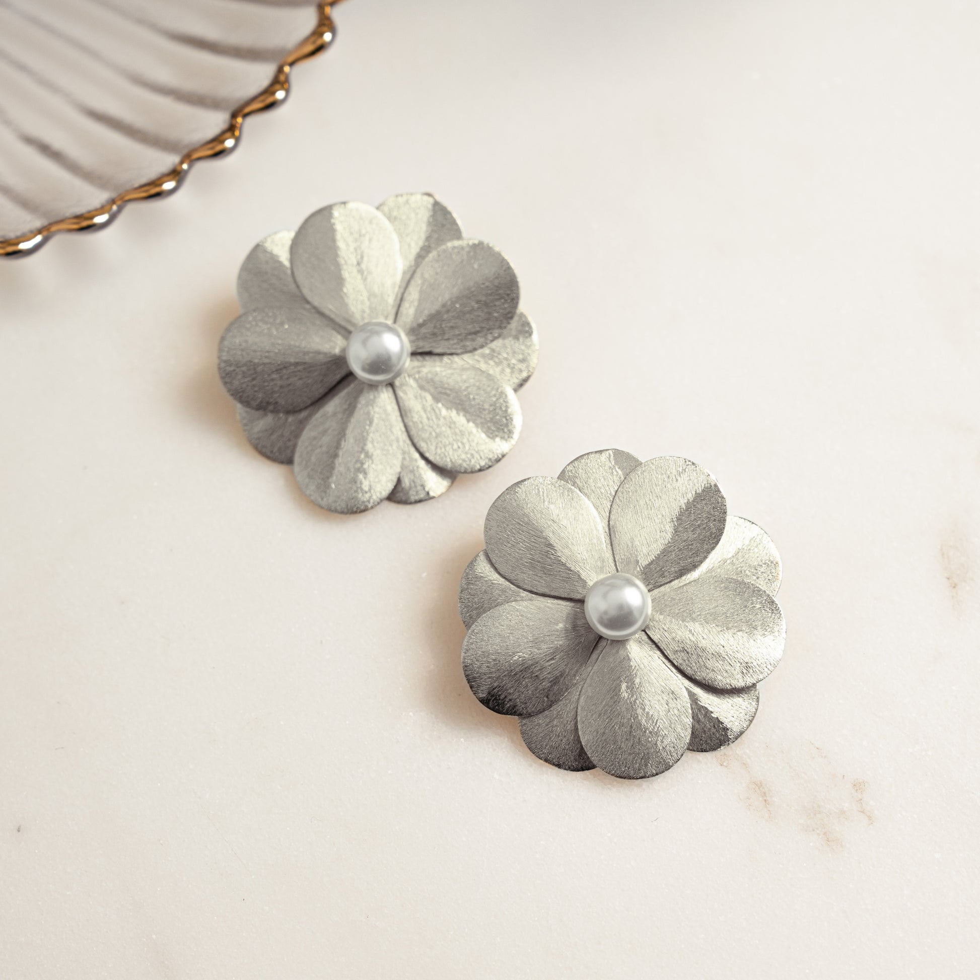 closeup image of statement earrings for the summer featuring a flower earring design