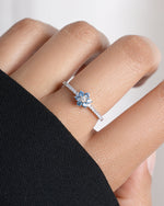 Model wearing sterling silver dainty gemstone ring with aquamarine stones
