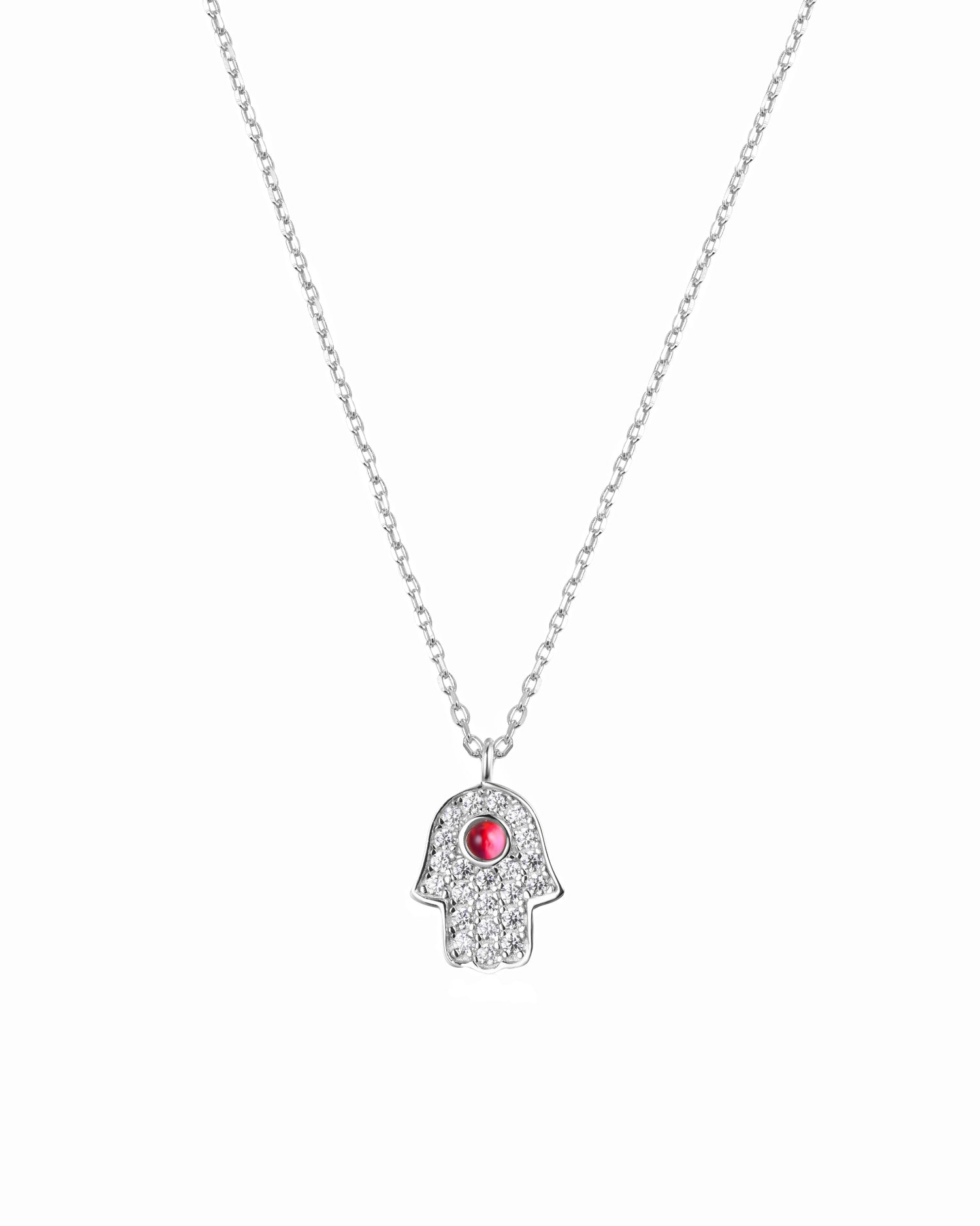 Silver necklace with a hamsa hand pendant featuring a red gemstone on a white background