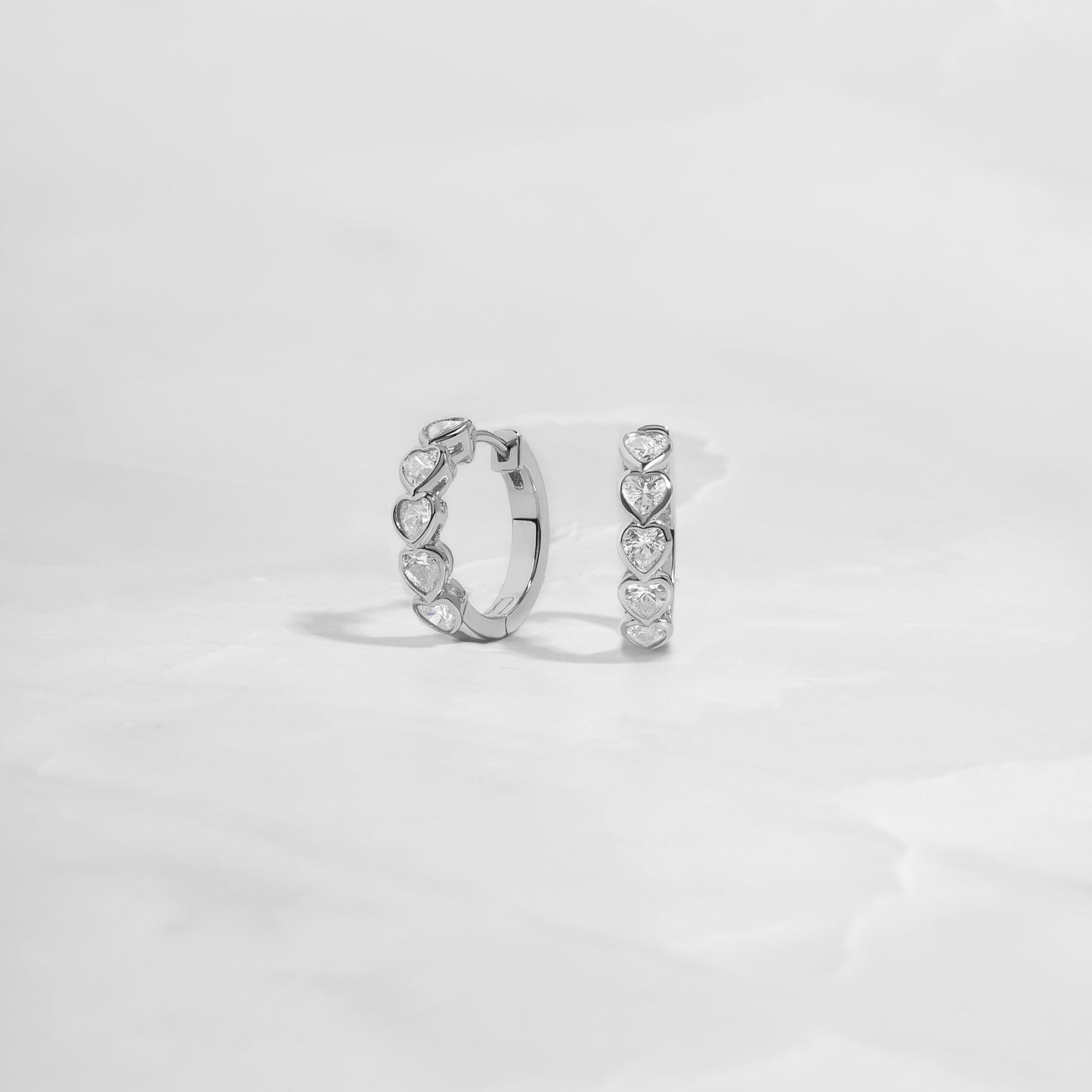 Huggie earrings in sterling silver with textured heart design.  