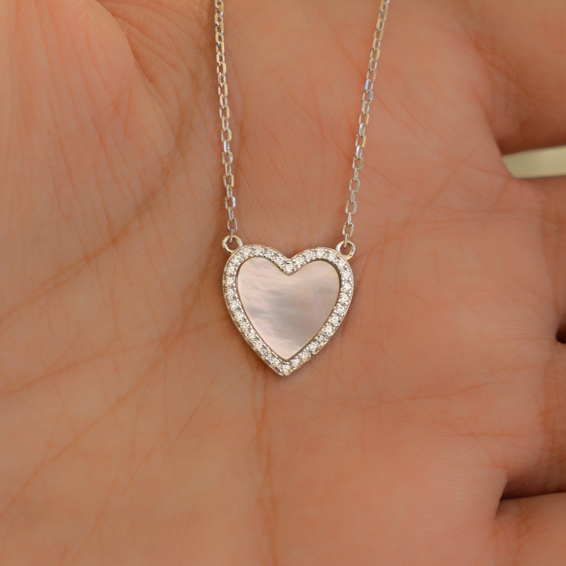 Mother of Pearl Necklace held on palm, with the light creating subtle rainbows across the pearl surface.