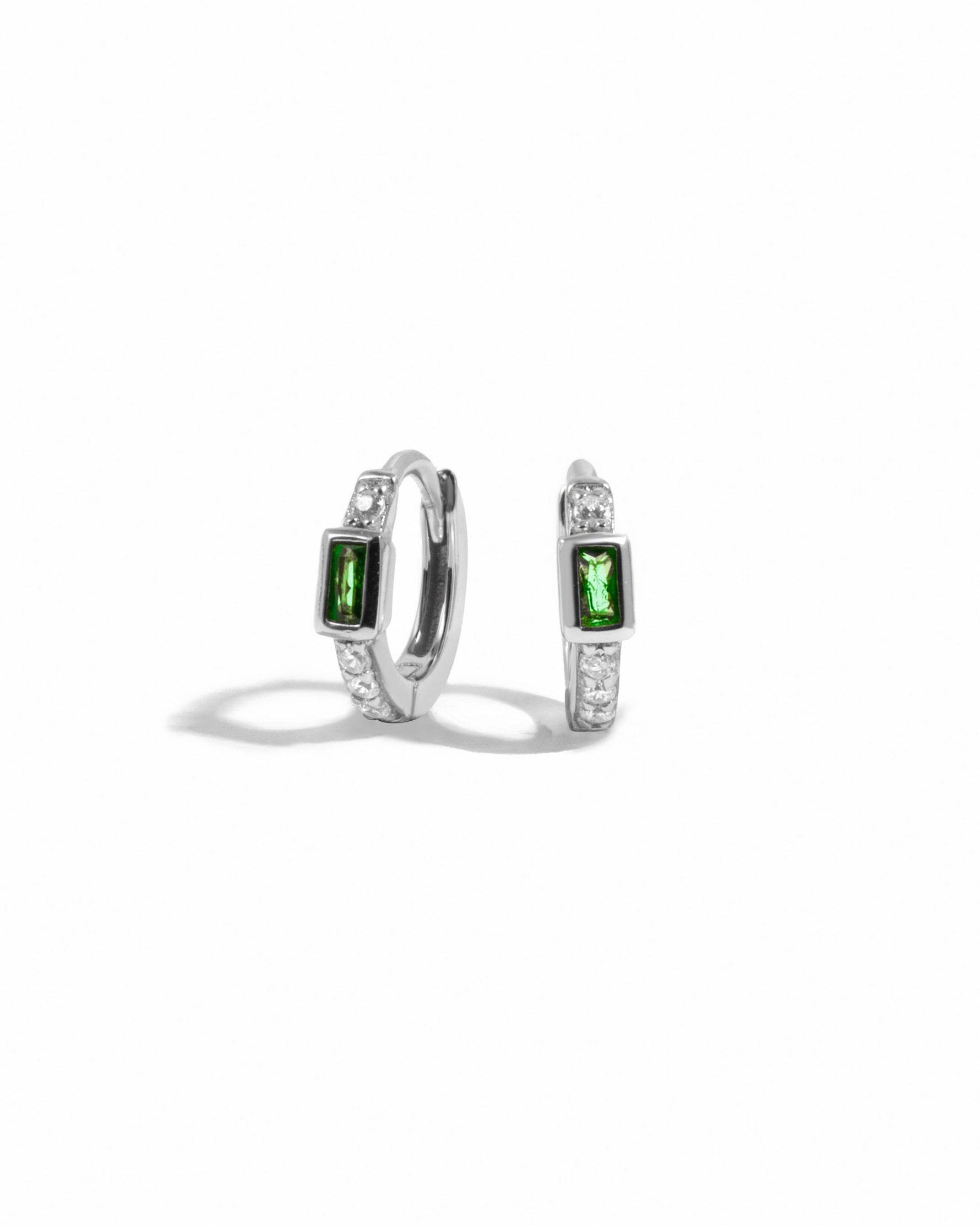 sterling silver cubic zirconia huggie hoops with an emerald green baguette stone in the center