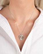 Model wearing vintage charm necklace with a heart pendant on a silver chain on model