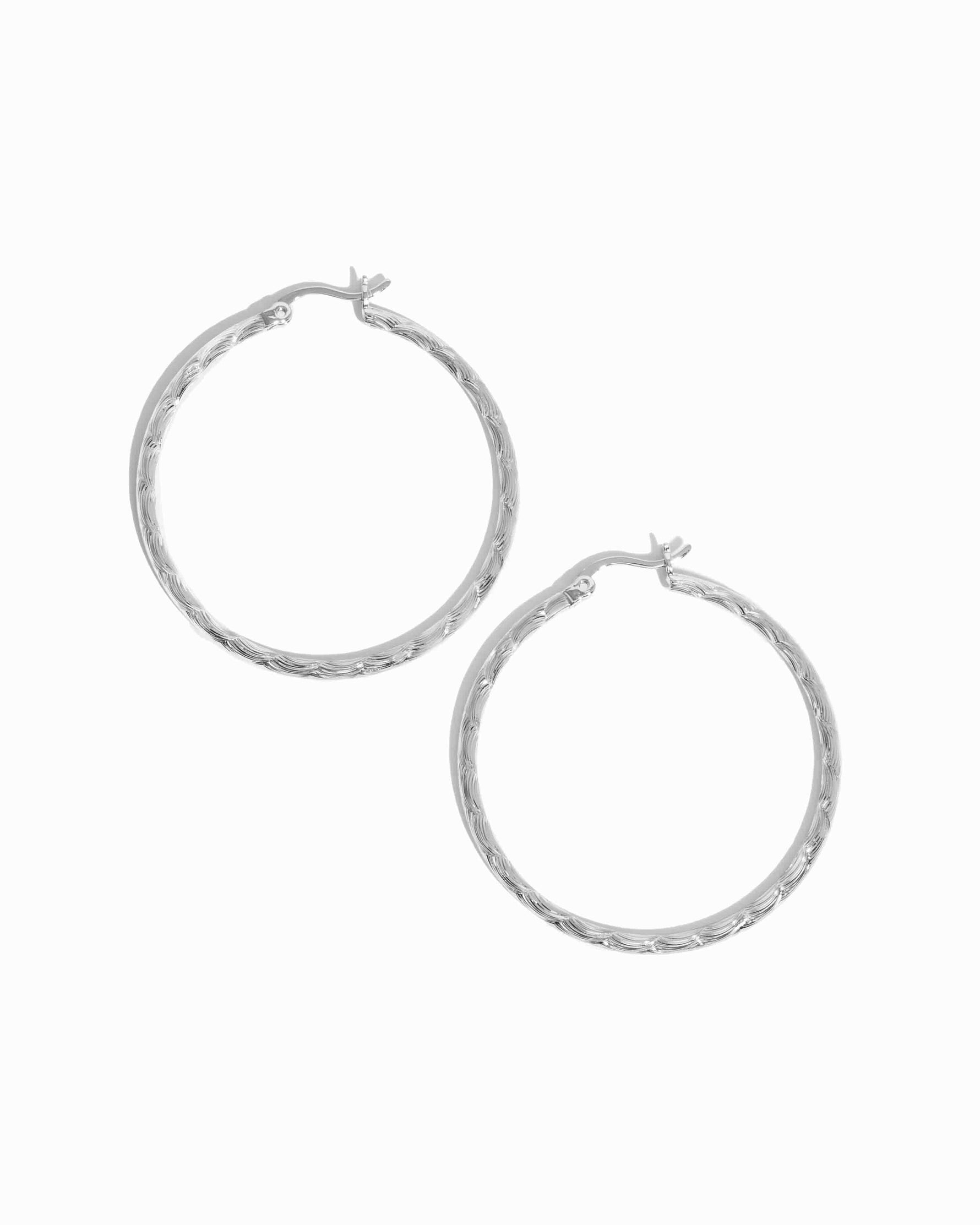 Pair of silver hoop earrings on a white background
