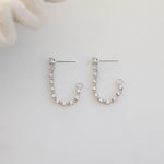 close up of silver front-back dangle earrings with tennis chain accents.