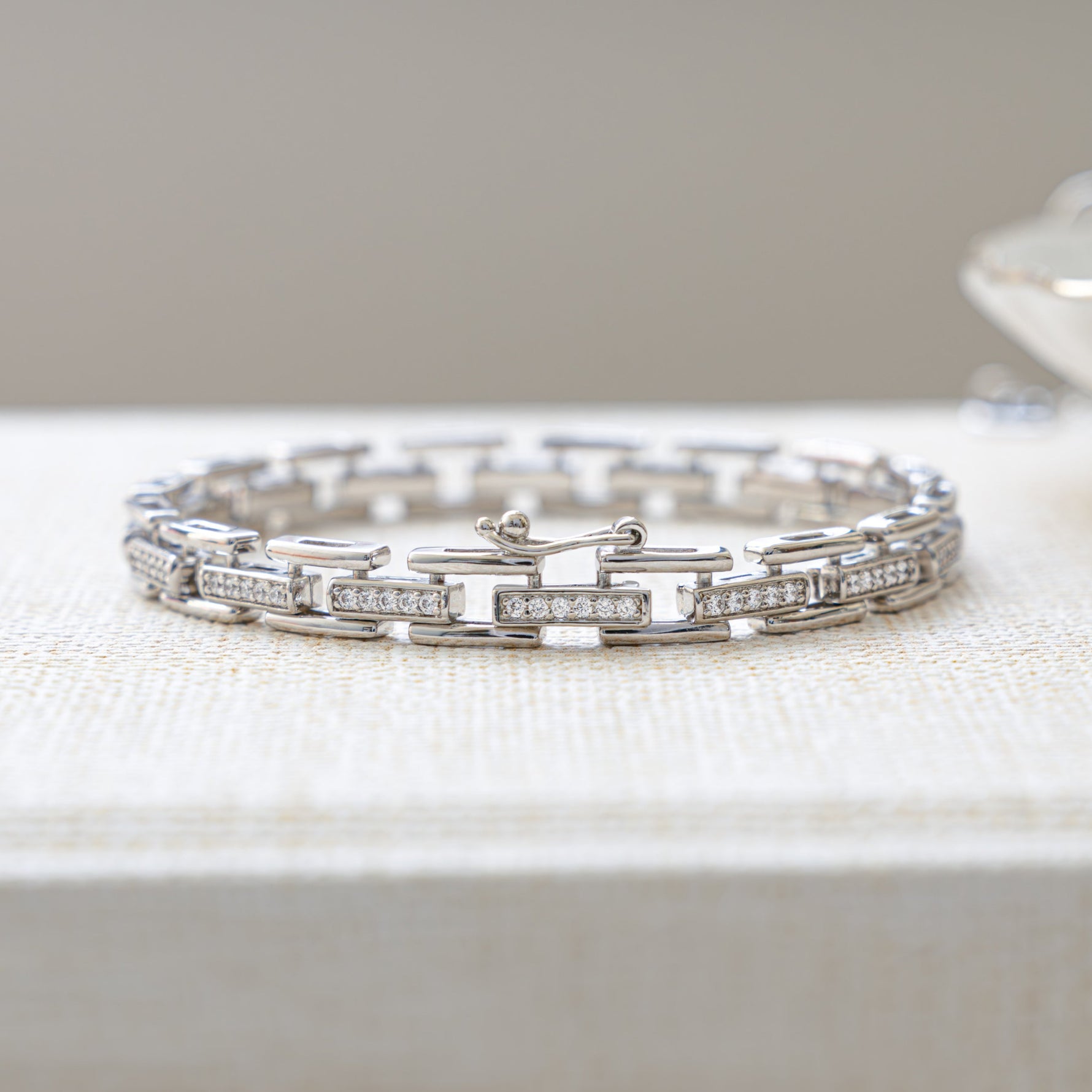 Closeup image of silver bracelet with chain link cubic zirconia design