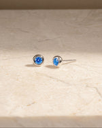 Sterling silver gemstone studs on a marble background