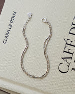 Sterling silver adjustable bracelet featuring a beaded bracelet design on a coffee table book