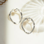 closeup image of silver modern earrings