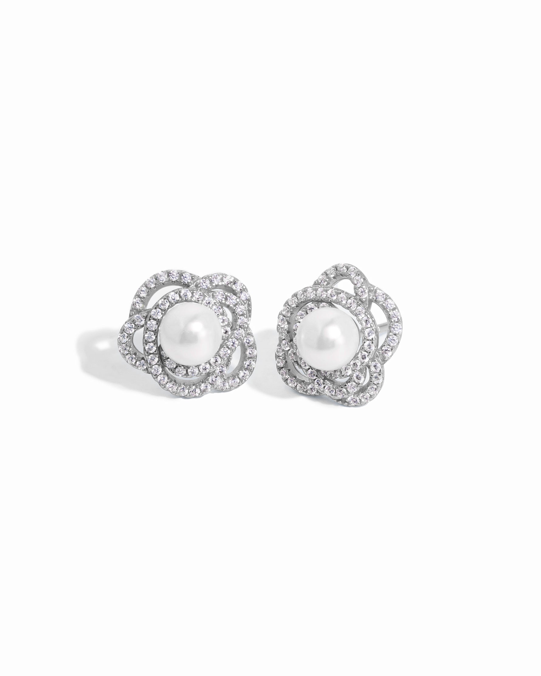 closeup image of sterling silver statement earrings with pearl earring design and floral earring design