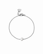 Silver bracelet with a small opal charm on a white background
