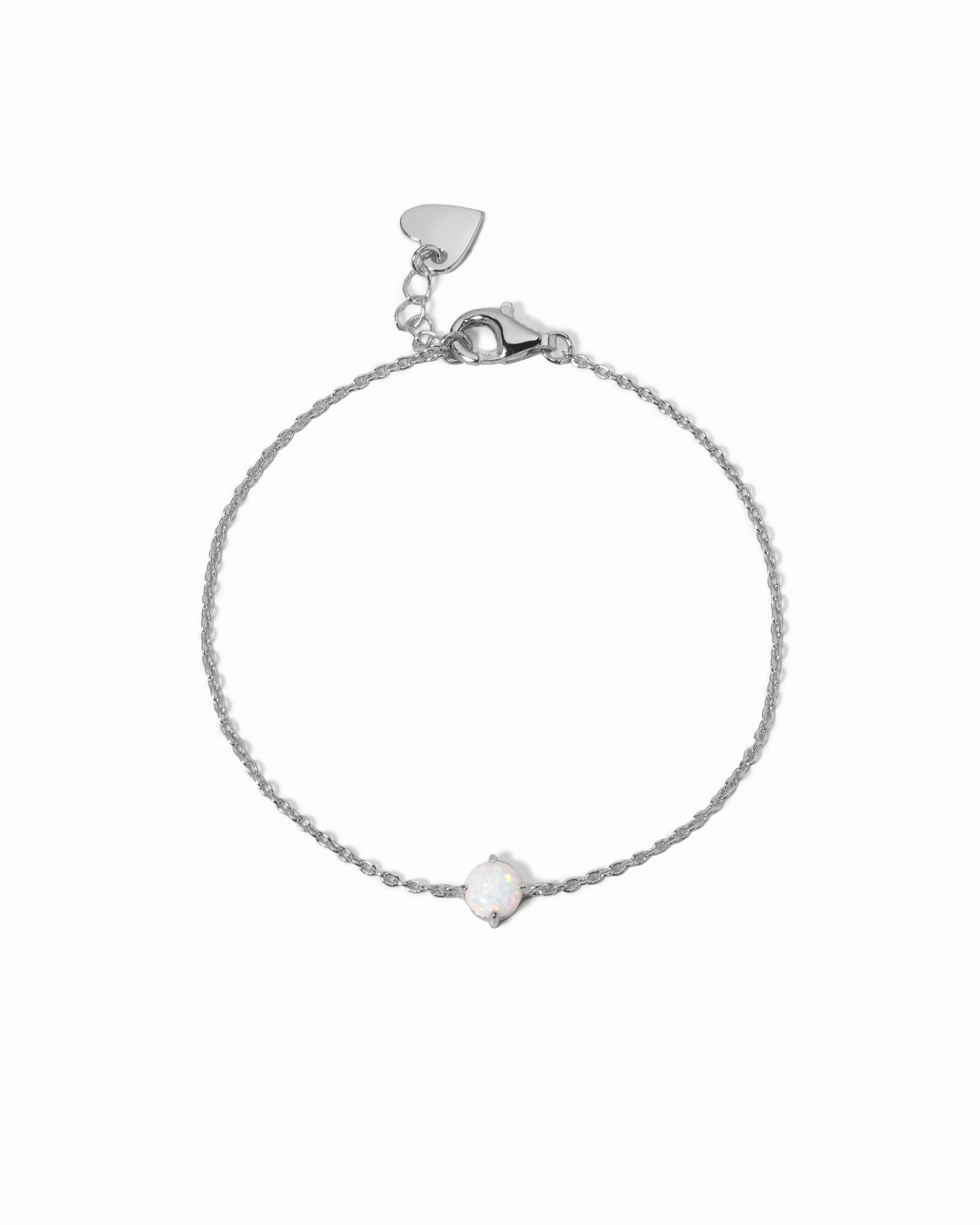 Silver bracelet with a small opal charm on a white background