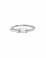 Silver ring with a small baguette gemstone and cz pave stones on a white background