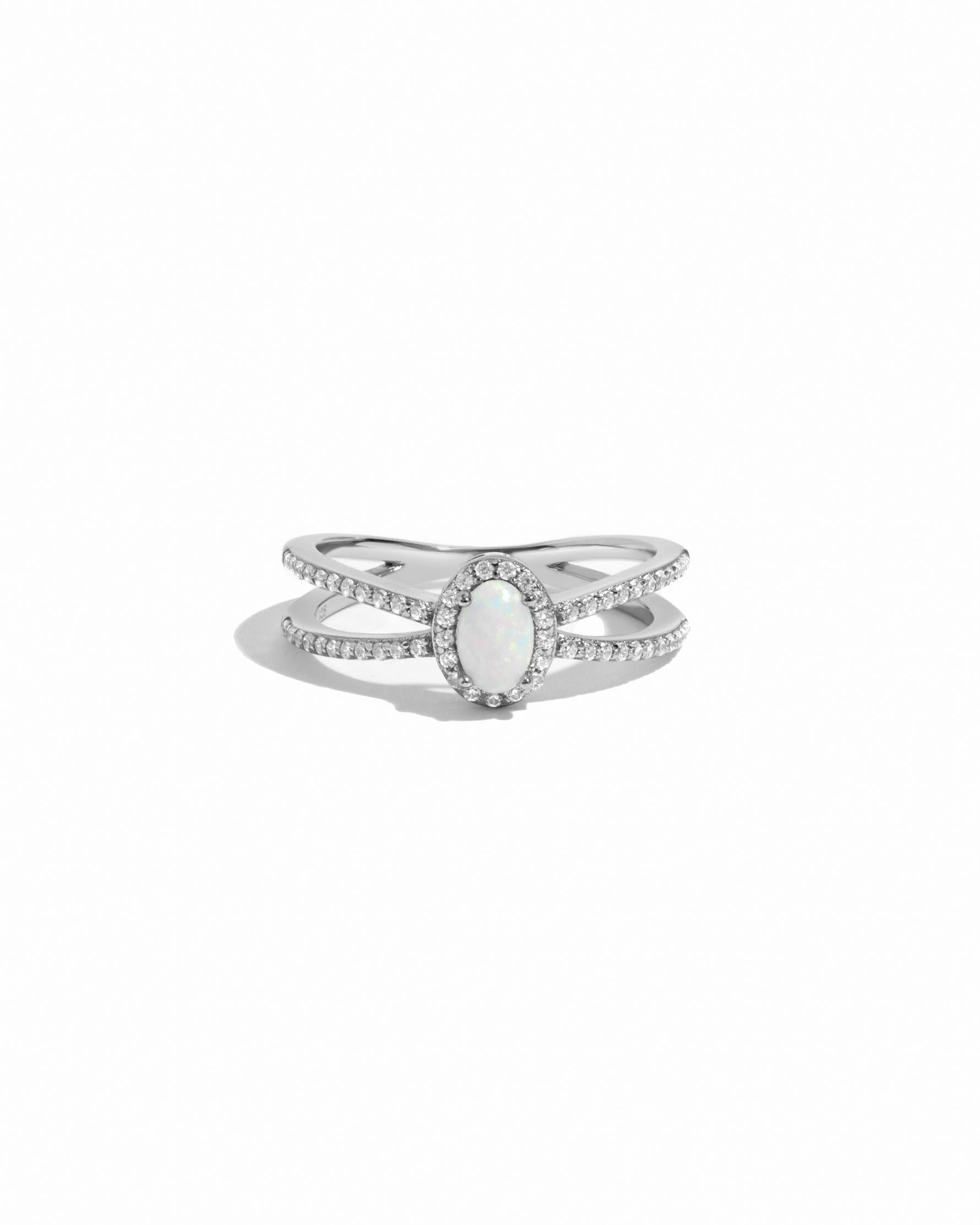 Silver ring with a central opal gemstone on a white background