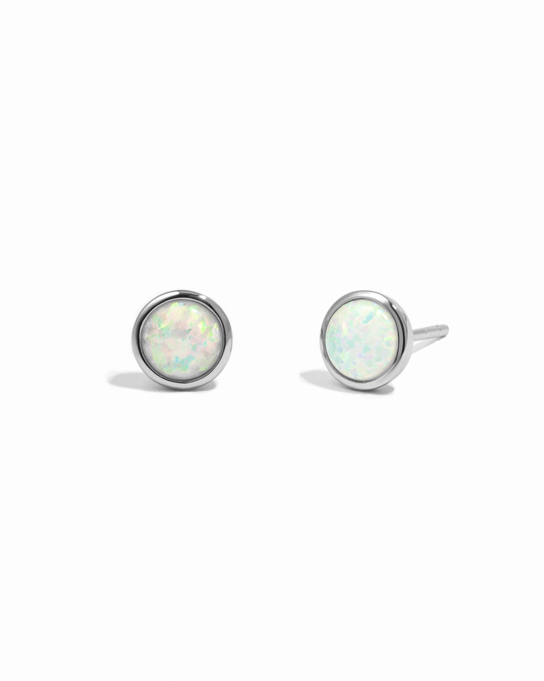 Pair of silver stud earrings with opal stones on a white background