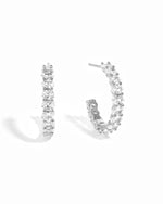 Silver hoop earrings with white cz stones on a white background