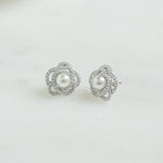 Closeup image of sterling silver stud statement earrings with floral design and pearl earring design