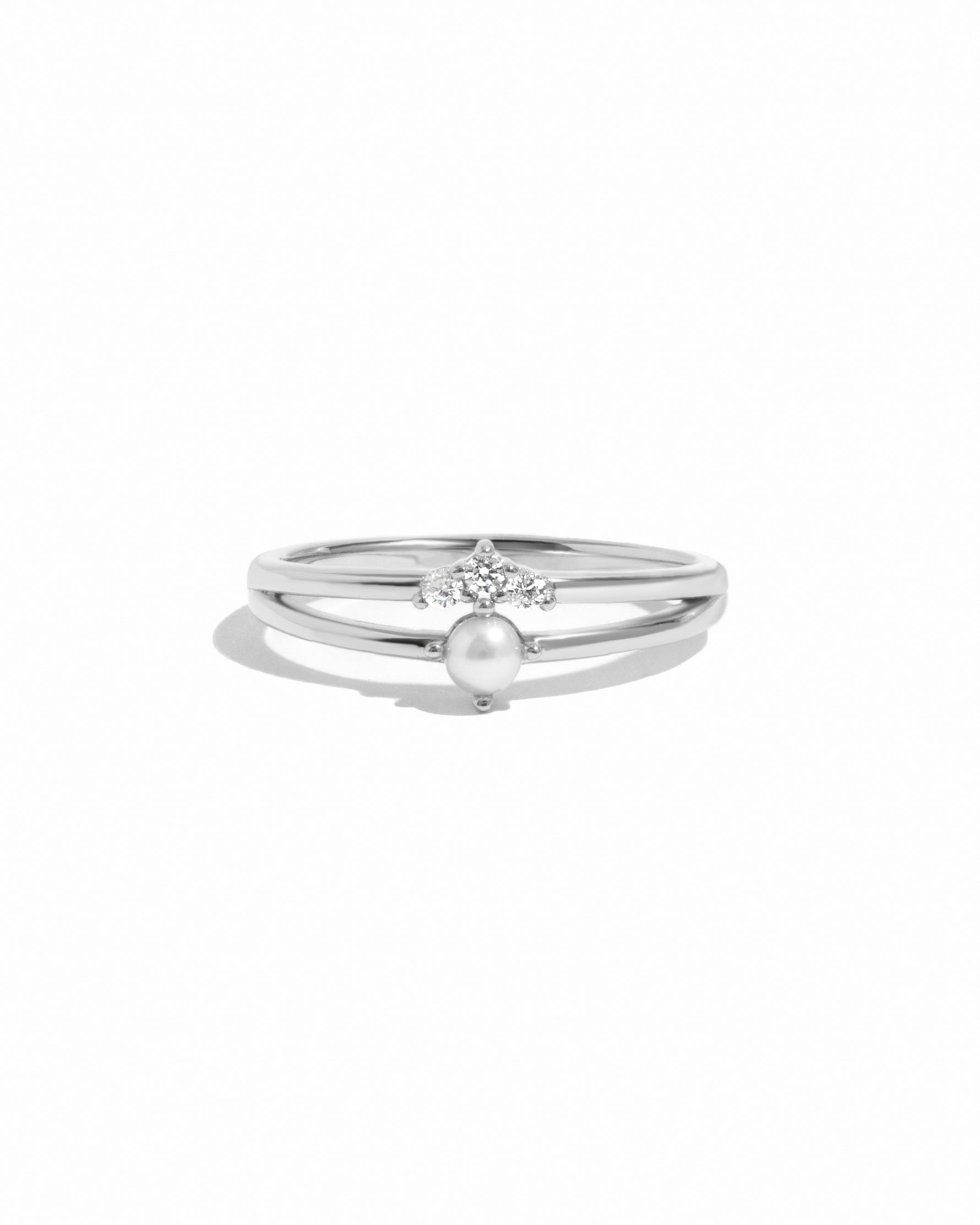 Silver ring set with a pearl and small diamonds on a white background