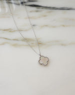 closeup image of silver chain pendant necklace with mother of pearl pendant