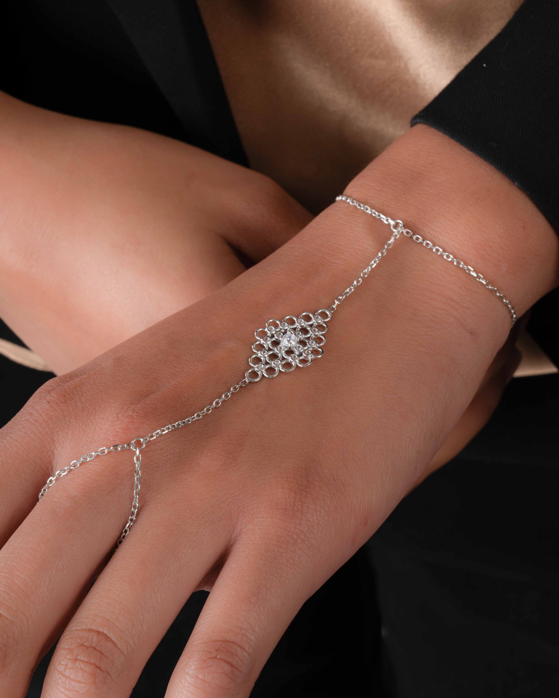 closeup image of model wearing silver hand chain bracelet 