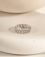 Silver chain ring on a white ceramic surface