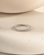 Silver ring on a beige ceramic surface