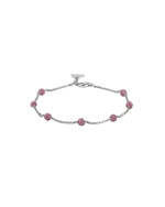 Silver bracelet with ruby beads on a white background