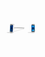 closeup image of minimalist blue earrings on a white background