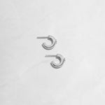 Closeup flatlay image of silver small chunky hoop earrings