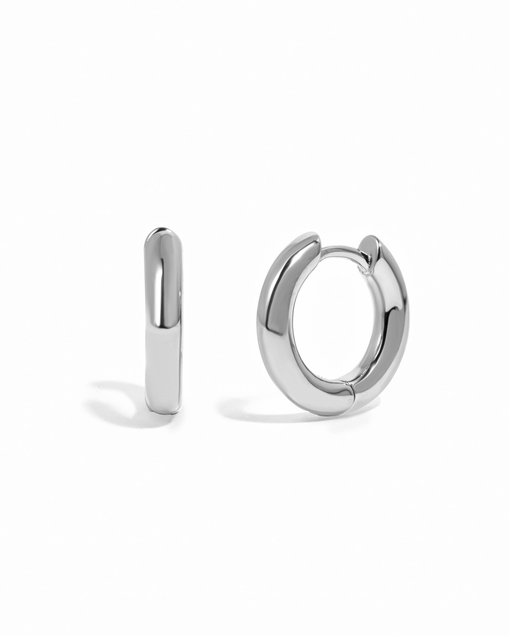 Pair of silver mini hoop earrings on a white background