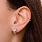 model wearing huggie earrings featuring cubic zirconia stones