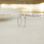 Closeup image of small hoop earrings wrapped in 925 sterling silver 