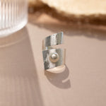closeup image of boho jewelry featuring a statement ring with freshwater pearl