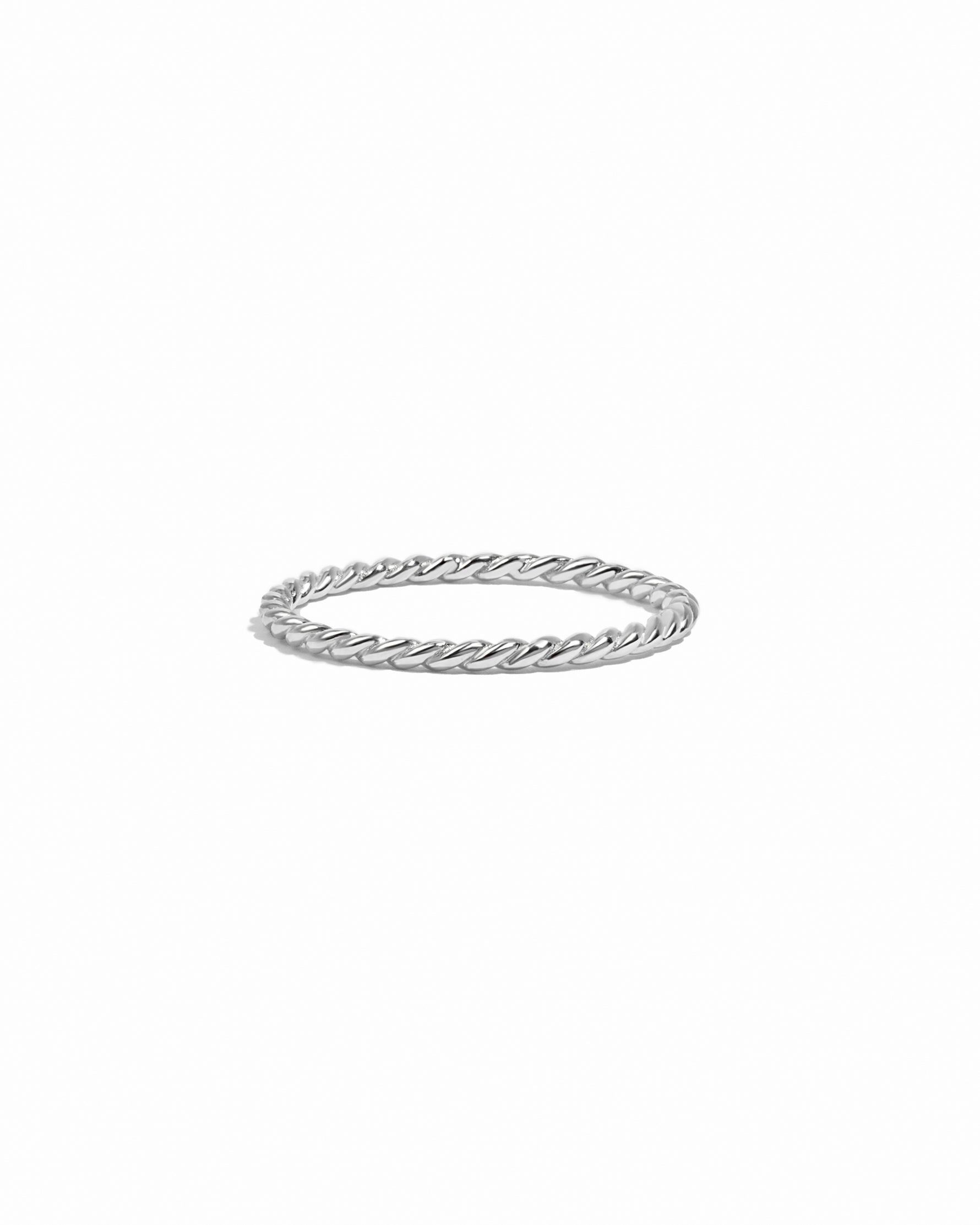 Silver ring with a twisted design on a white background