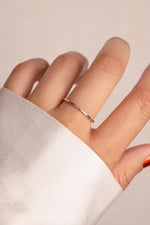 Delicate thin sterling silver stacking ring on model. 