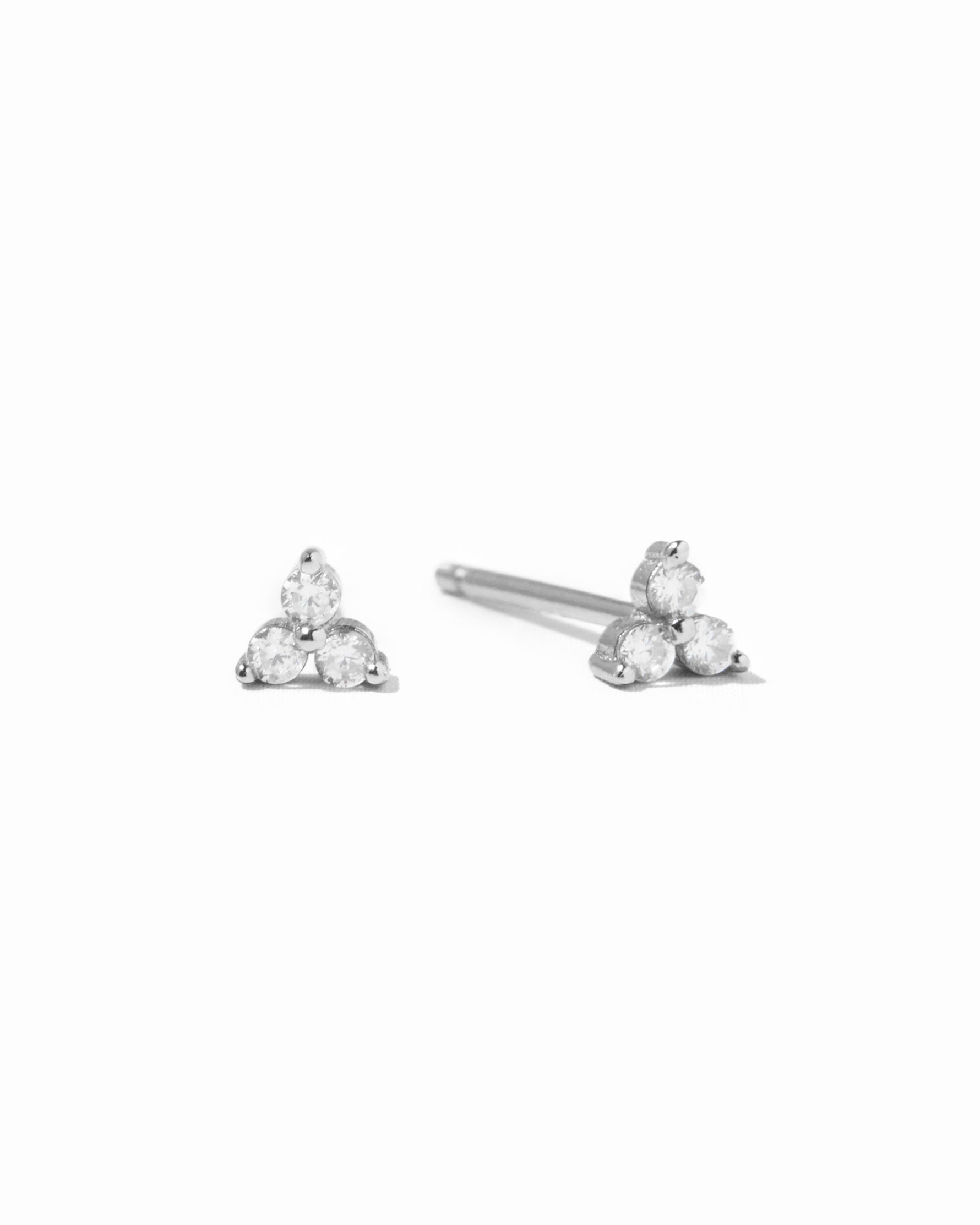 Pair of silver  triangle-shaped 3 stone stud earrings on a white background