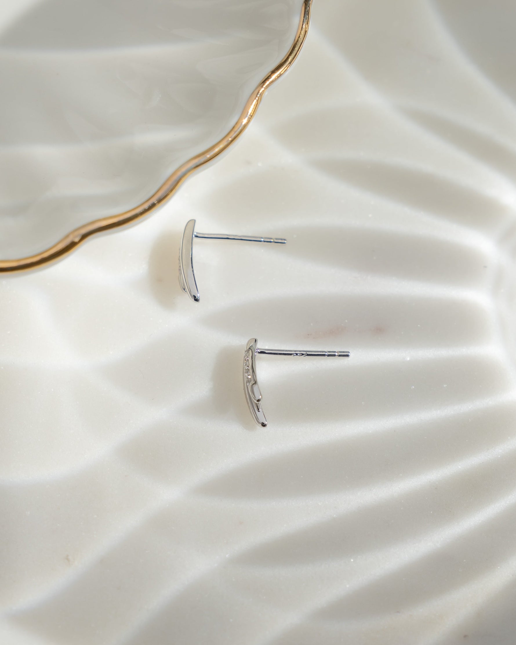 Sterling silver tiny earrings on a plain surface