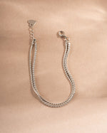 Sterling silver chain bracelet and diamond bracelet set on a neutral background