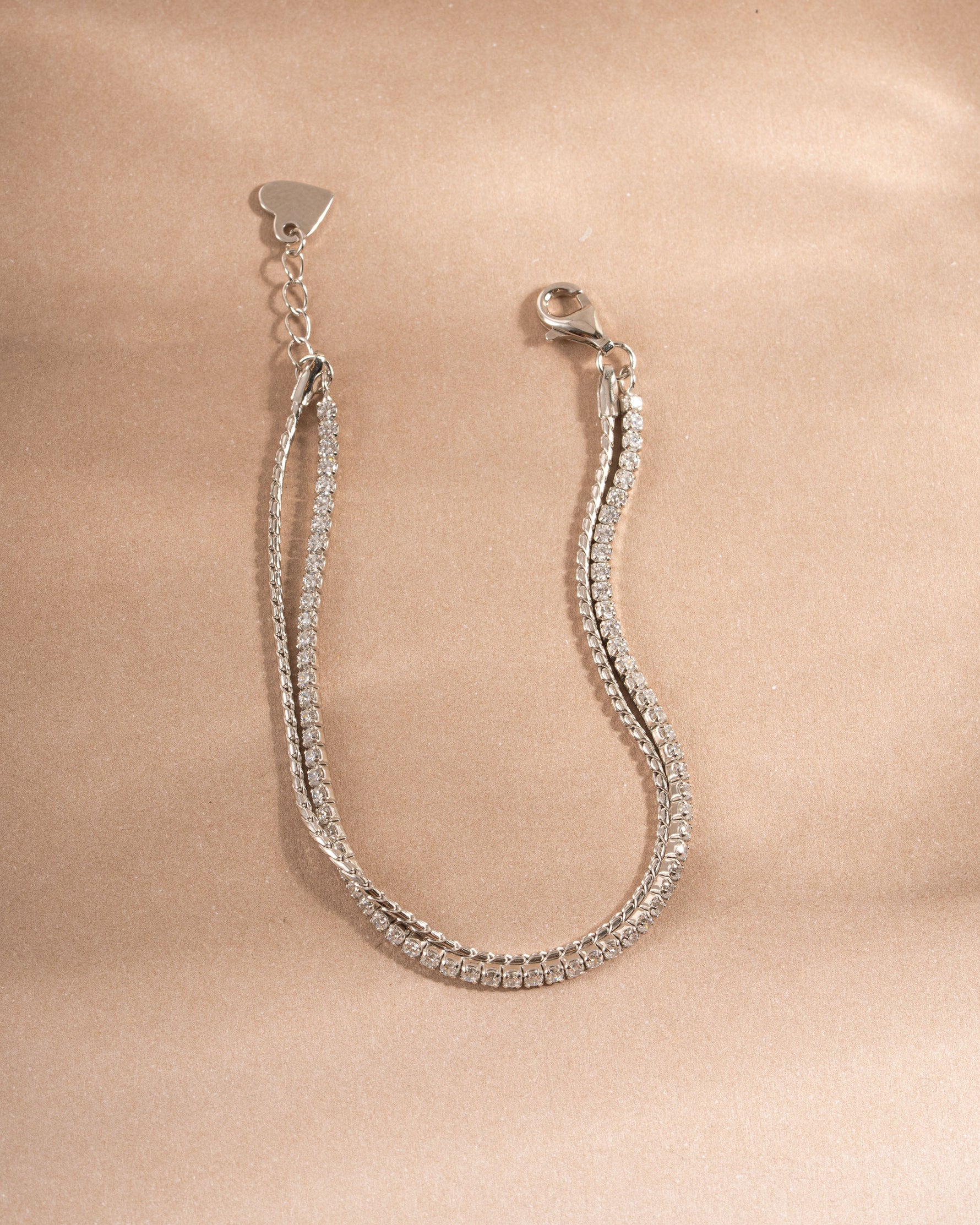 Sterling silver chain bracelet and diamond bracelet set on a neutral background