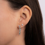 Model wearing tennis chain stud earrings paired with diamond stud earrings, set in silver 