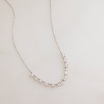 Flatlay image of silver diamond necklace with baguette stones