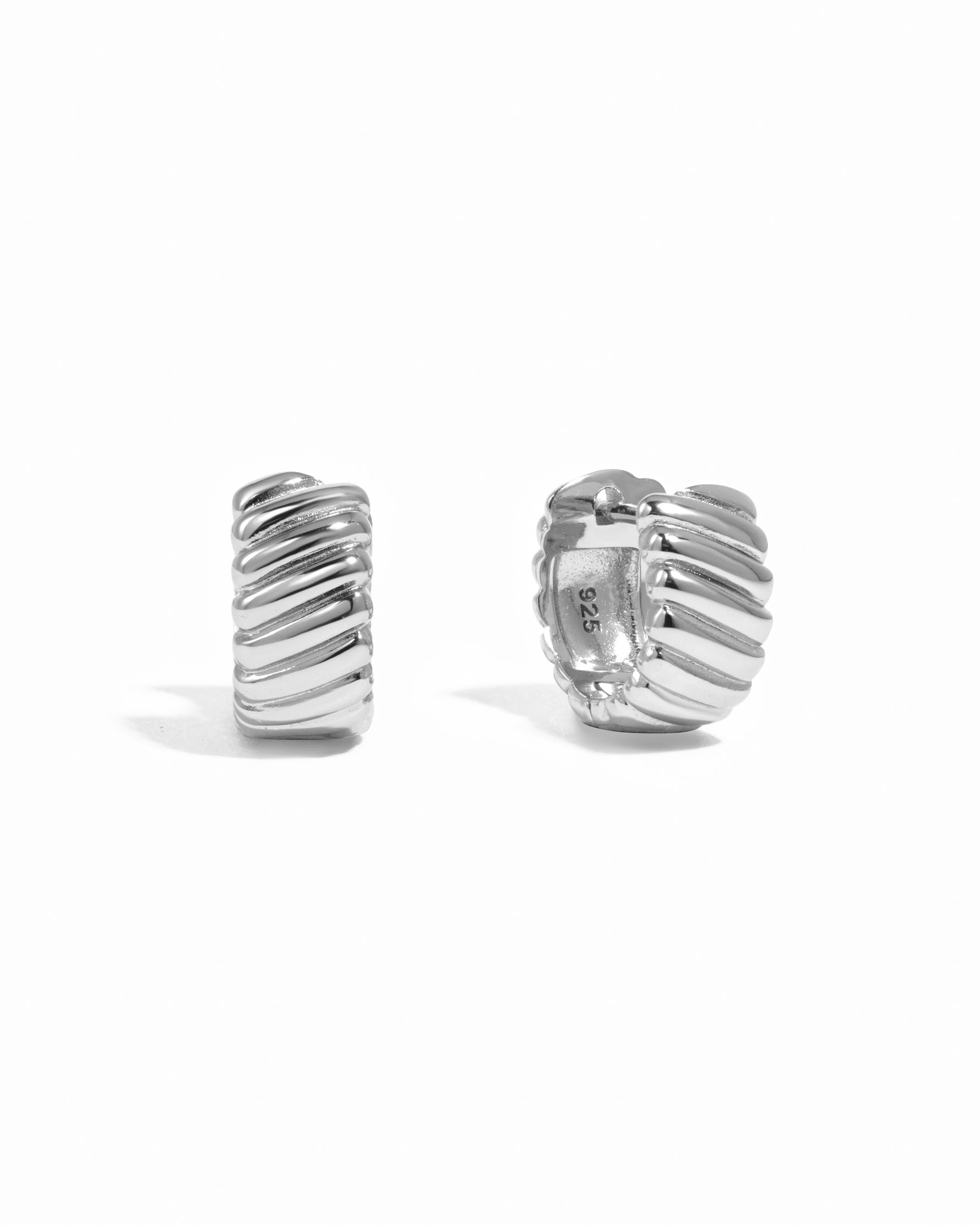 Silver textured hoop earrings on a white background