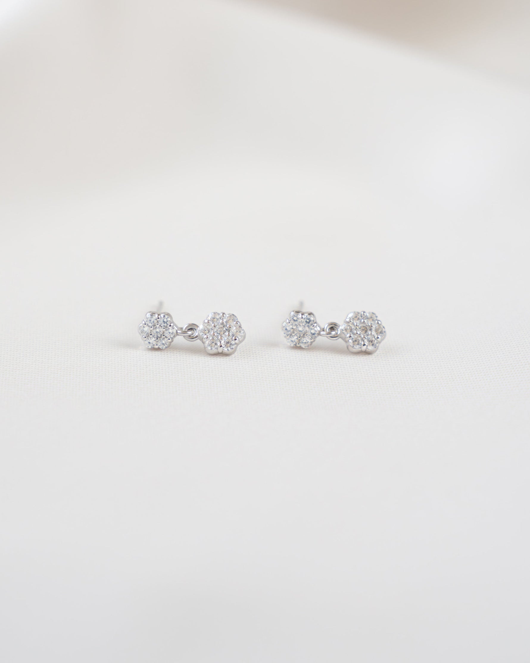 Pair of floral earrings with a drop earring design on a white background