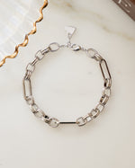 Silver statement jewelry chain bracelet on a marble surface 