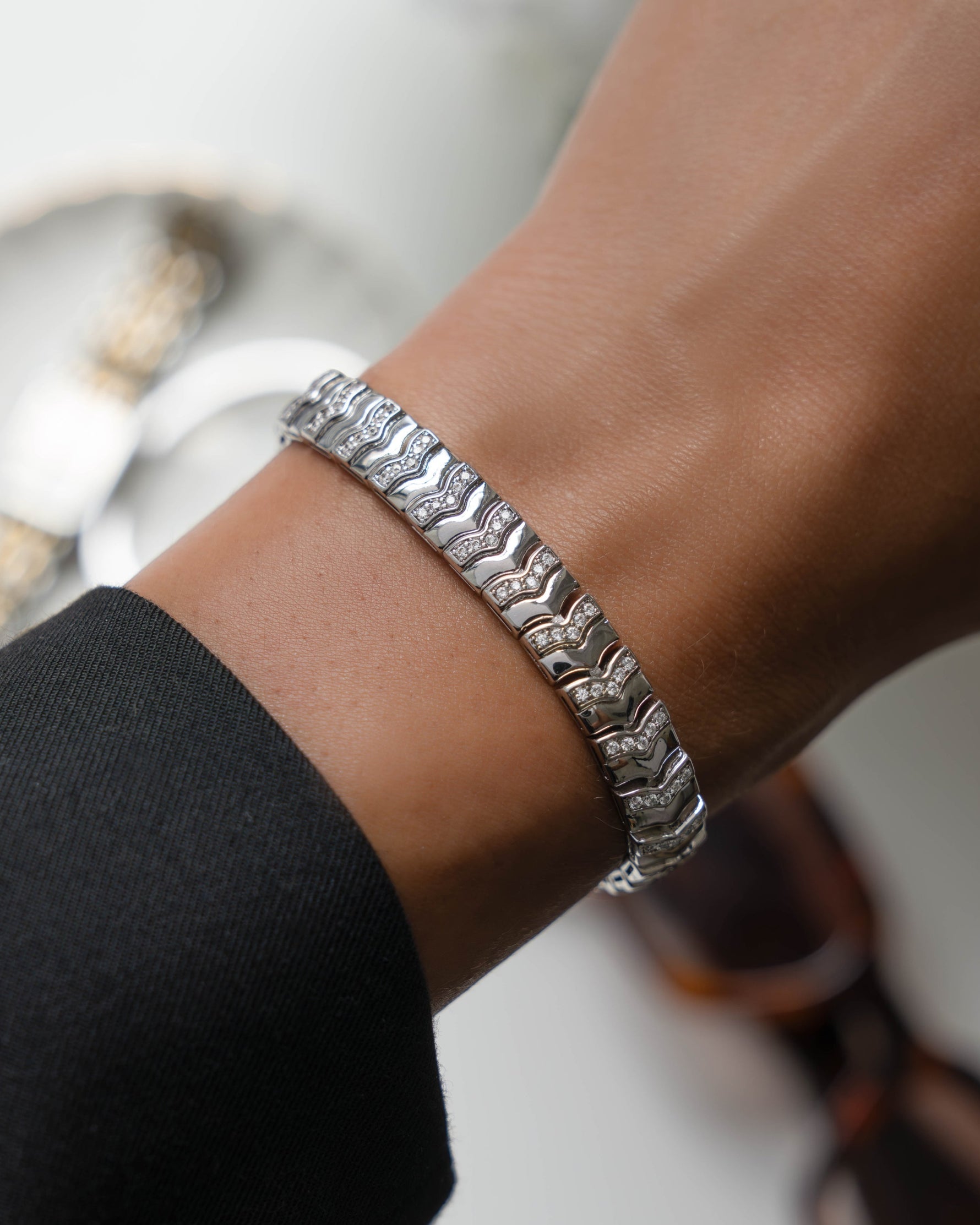 Model wearing silver chain chevron bracelet on a white background