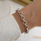 Model wearing silver bracelet with silver chain