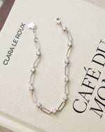 Silver chain bracelet on coffee table book