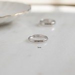 Flat lay of a silver ring, smooth and polished, perfect as a wedding band.