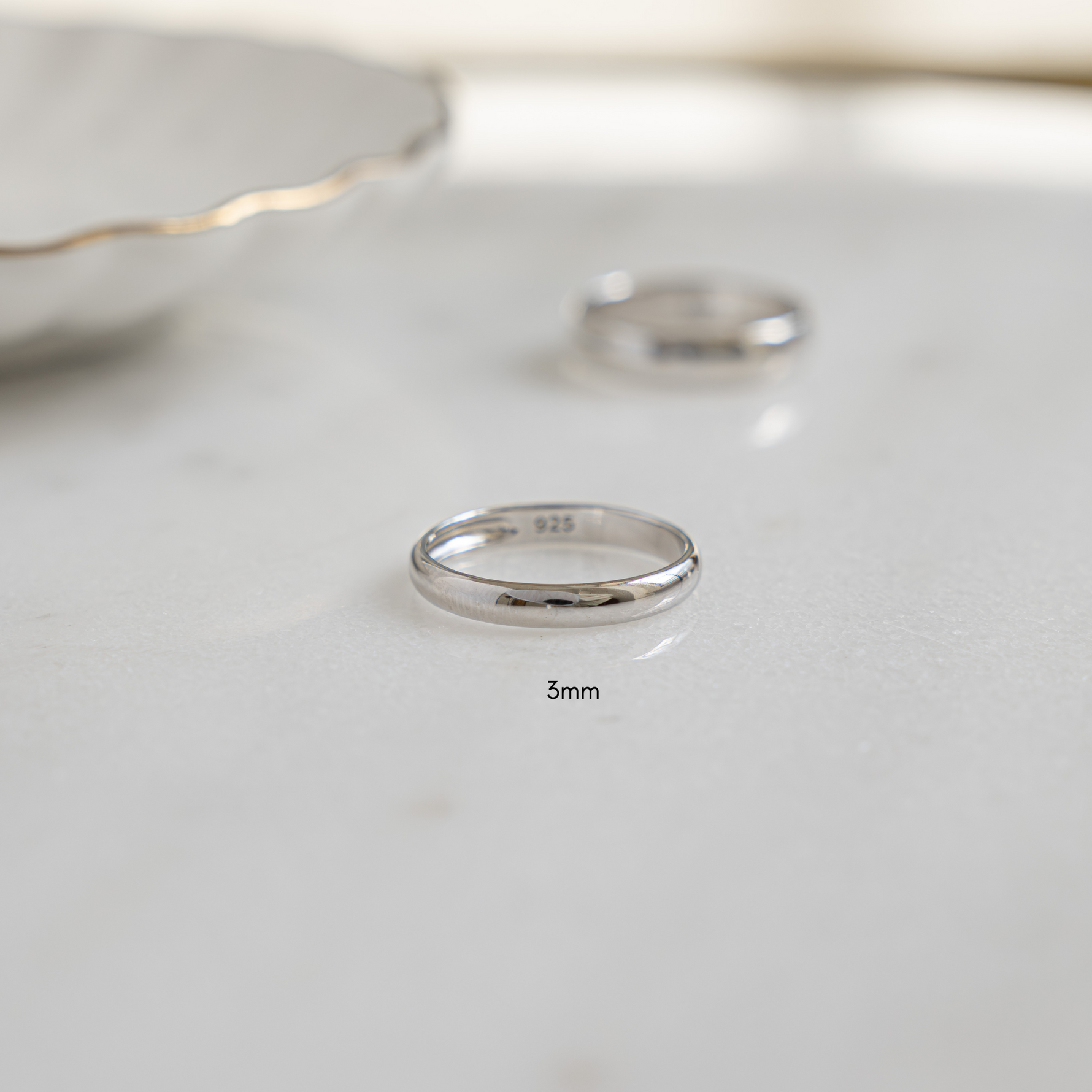 Flat lay of a silver ring, smooth and polished, perfect as a wedding band.