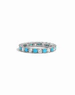 Eternity ring with turquoise and white cz stones on a white background